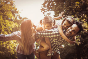 Familia de madre, padre y dos niñas jugando al aire libre