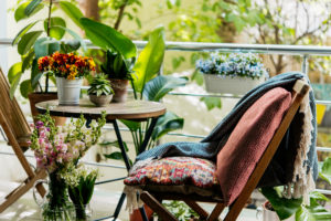 Terraza con una silla y una mesa, decorada con plantas y estilo boho