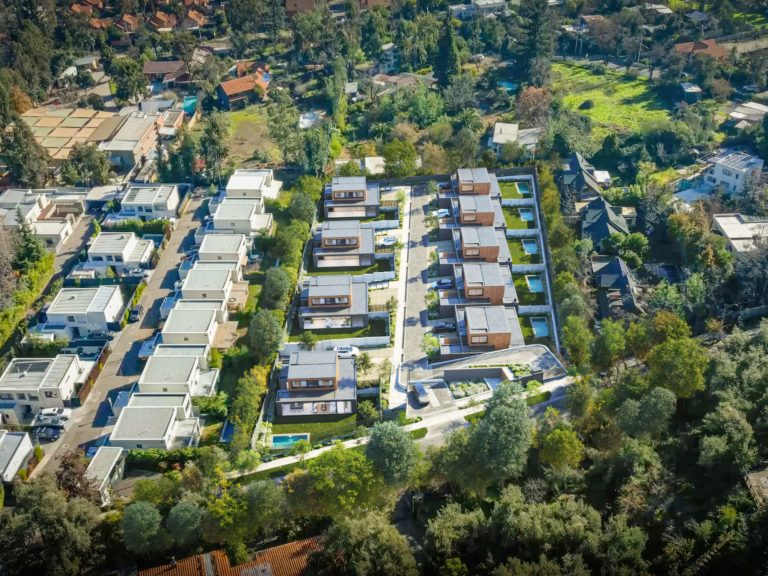 Vista aérea del condominio de nueve casas rodeadas de árboles