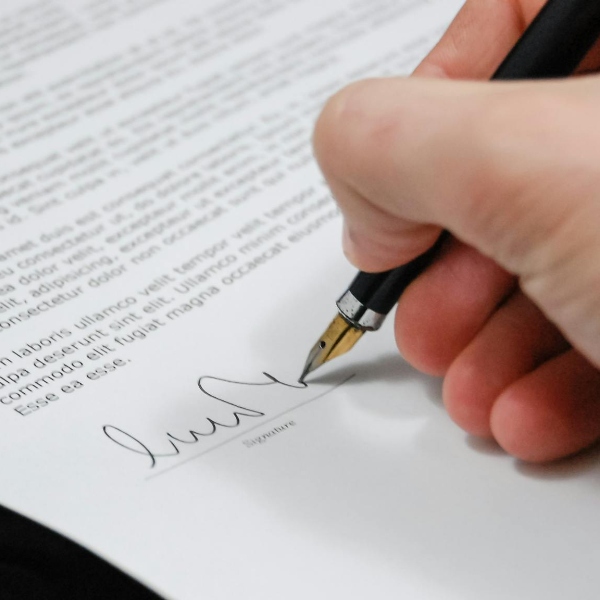 Una mano firmando un documento