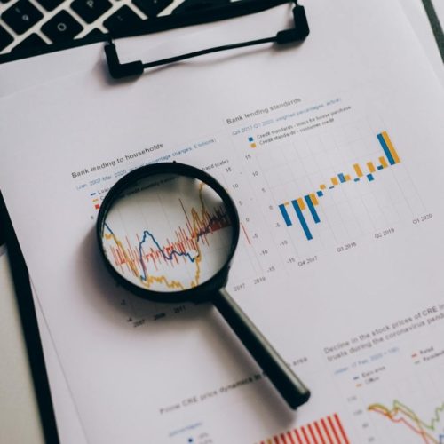 Una lupa sobre unos documentos con gráficos